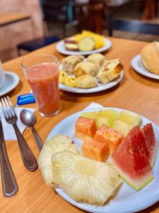 two plates of food on a table with plates of fruit at Hotel Porto Salvador in Salvador +31 photos