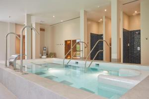 a hot tub in a room with a large mirror at The Retreat Elcot Park in Newbury