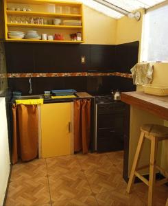 uma cozinha com armários pretos e electrodomésticos amarelos em BiosWild em Cusco