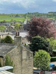 a view of a town with houses and trees at Cute and cosy 2 bed cottage in Honley