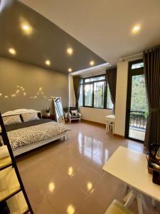 a bedroom with a bed and a living room at Grey House in Da Lat