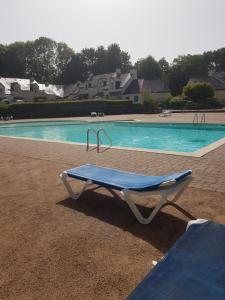 a blue bench in front of a swimming pool at Chez Christine in Ploemel +8 photos