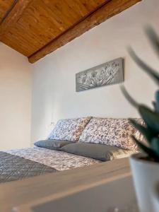 una camera con un letto in una stanza con una pianta di Biancofino Rooms a San Valentino in Abruzzo Citeriore