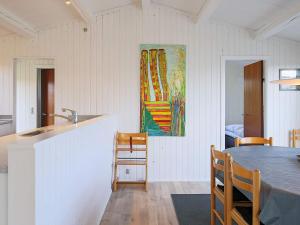 a kitchen with a table and a painting on the wall at 6 person holiday home in Gedser in Gedser