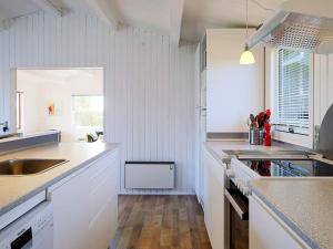 a kitchen with white cabinets and a sink at 6 person holiday home in Gedser in Gedser