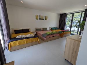 2 Betten in einem Zimmer mit Fenstern in der Unterkunft Villa Zenna Long Hải - Mimosa 611 View Biển in Long Hải