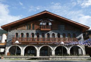 a large building with a balcony on top of it at Hotel Posta in Mestia