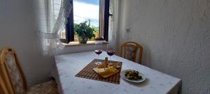 a table with a plate of food and two glasses of wine at Apartma pr' Ivani Miškorinovi in Breginj