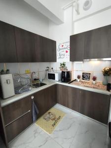 a kitchen with brown cabinets and a sign on the floor at Prestige Troika Kota Bharu in Kota Bharu