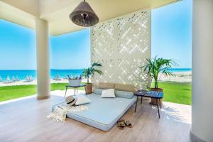 a living room with a couch and a view of the beach at Ammoa Luxury Hotel & Spa Resort in Nikiti