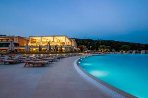 a resort with a swimming pool with chairs and umbrellas at Ammoa Luxury Hotel & Spa Resort in Nikiti