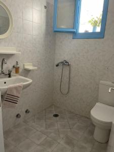 uma casa de banho com um chuveiro, um WC e um lavatório. em Mihaela Apartments Sifnos em Faros