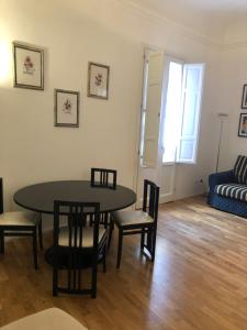 sala de estar con mesa, sillas y sofá en Bijou Apartment, en Trapani