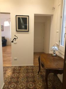 a room with a table and a television on a wall at Bijou Apartment in Trapani