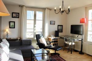 a living room with a couch and a table at L'entre port & mer - Vue mer - Proxi gare plage & quai - Hyper-Centre - Parking gratuit in Dieppe