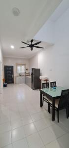 a living room with a table and a ceiling fan at Voon 4 bedroom homestay Mersing in Mersing