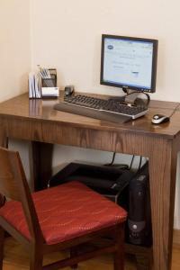 a desk with a computer monitor and a keyboard and mouse at Baymont by Wyndham Oklahoma City/Quail Springs in Oklahoma City