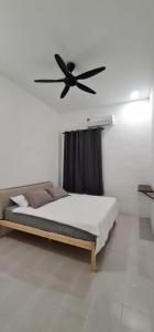 a bedroom with a bed with a ceiling fan at Voon 4 bedroom homestay Mersing in Mersing