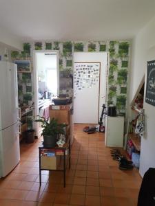 a room with a kitchen with a table and a door at Chez Christine in Ploemel