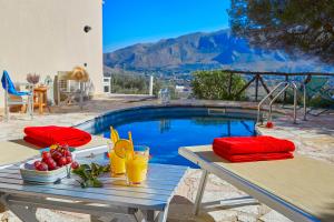 a picnic table with a bowl of fruit next to a pool at Villa Rosa Dei Venti - Scopello-Villas in Scopello