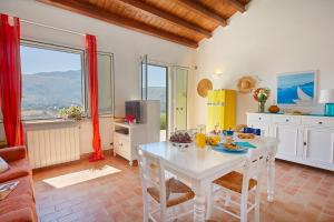 スコペッロにあるVilla Rosa Dei Venti - Scopello-Villasのキッチン、リビングルーム(白いテーブル、椅子付)