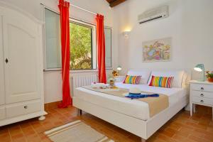 スコペッロにあるVilla Rosa Dei Venti - Scopello-Villasのベッドルーム1室(赤いカーテンと窓付きのベッド1台付)