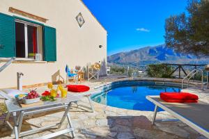 a patio with a table and a swimming pool at Villa Rosa Dei Venti - Scopello-Villas in Scopello