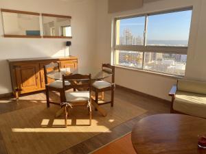 a living room with a table and chairs and a desk at Charming apartment with sea view in Armação de Pêra - 70 m² in Armação de Pêra