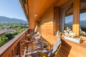 a balcony of a house with chairs and tables at Charmantissime appartement avec vue montagnes - 3 ch, LLA Selections by Locationlacannecy in Saint-Jorioz
