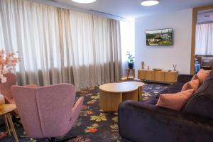 a living room with a couch and chairs and a table at Hotel Opal Home in Sarajevo