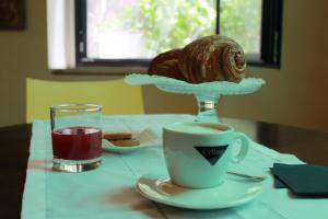 a cup of coffee and a croissant on a table at Hotel Touring in Livorno