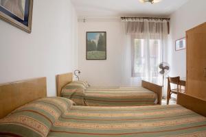 a bedroom with two beds and a window at Villa Carolina in San Felice del Benaco