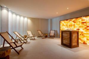 a row of chairs in a room with a fireplace at Ammoa Luxury Hotel & Spa Resort in Nikiti