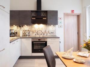 a kitchen with white cabinets and a wooden table at Ferienwohnung Alte Bäckerei Werlte in Werlte