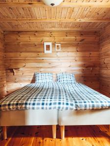una camera con un letto su una parete in legno di Noretjärns Stugby a Årjäng