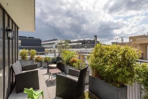 balkon z krzesłami i roślinami w budynku w obiekcie ILLANKA - Appartement 3 chambres avec parking et terrasse proche gare w mieście Rennes