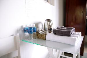 a white table with towels and water bottles on it at Grey House in Da Lat