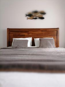 uma cama com cabeceira e almofadas de madeira em 09PuzzleSuites em Bucareste