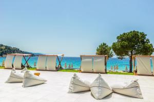 a row of empty pillows on a patio near the ocean at Ammoa Luxury Hotel & Spa Resort in Nikiti