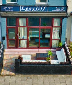 a building with a bench in front of a store at Leecliff Guest House in Blackpool