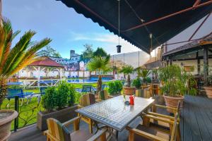 eine Terrasse mit einem Tisch, Stühlen und einem Pool in der Unterkunft Hotel Korona in Sighişoara