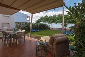 a patio with a couch and a table with a view of the ocean at Nikogroup By the Sea 3 in Polychrono