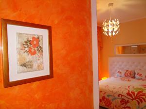 1 dormitorio con una pared de color naranja, 1 cama y 1 foto en Orange Flower Apartments 1, en Sofía