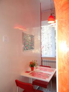 a dining room with a white table and red chairs at Orange Flower Apartments 1 in Sofia