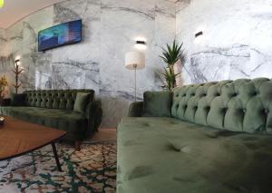 - un salon avec un canapé et une télévision murale dans l'établissement Hotel-VH, 