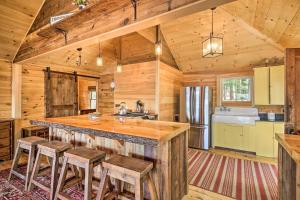 a kitchen with a large island in a log cabin at Lakefront Cottage Boat Dock, Patio and Kayaks! in Oxford
