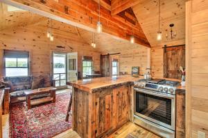 a log cabin kitchen with an island in the center at Lakefront Cottage Boat Dock, Patio and Kayaks! in Oxford
