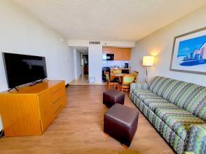 a living room with a couch and a flat screen tv at The Barclay Towers Hotel and Resort in Virginia Beach