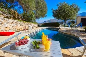 a table with fruit on it next to a swimming pool at Villa Del Sol - Scopello-Villas in Scopello