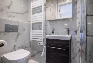 La salle de bains blanche est pourvue d'un lavabo et de toilettes. dans l'établissement The Coach House - Modernised 1 Bedroom Flat, moments from the beach, à Bournemouth